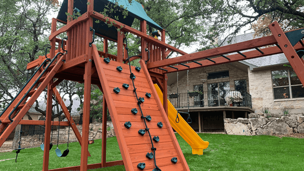 Big tall wooden playset with monkey bars.