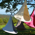 Colorful tents hanging from trees with a scenic background
