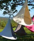 Colorful tents hanging from trees with a scenic background
