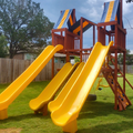 Colorful playground with yellow slides and a wooden structure on grass