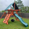 Playset with slide and climbing wall on grassy area