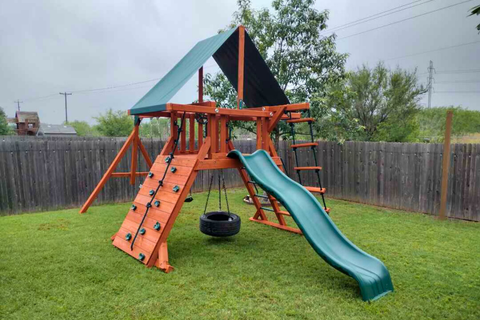 Playset with slide and climbing wall on grassy area