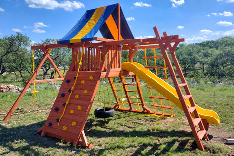 Colorful playground structure with slides and climbing wall in an outdoor setting.