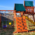 Wooden playground set with swings and slides in a backyard