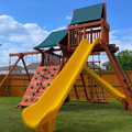 Children's playground with a yellow slide and climbing structure on a grassy area.