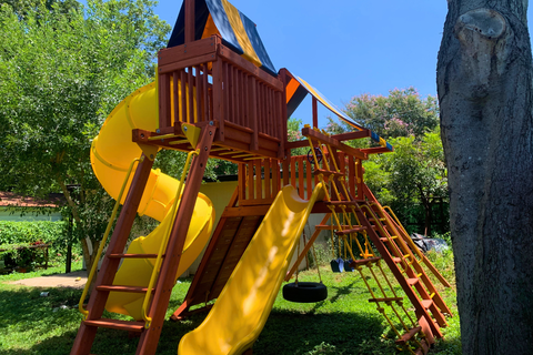 Children's playground with yellow slides and wooden structure in a park setting.