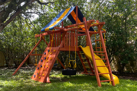 Colorful playground set with slides and swings in a backyard setting.