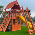 Wooden playground set with slides and climbing structures on a grassy area.