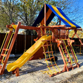 Colorful playground set with a slide and climbing structure in an outdoor setting.