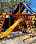 Colorful playground set with a slide and climbing structure in an outdoor setting.