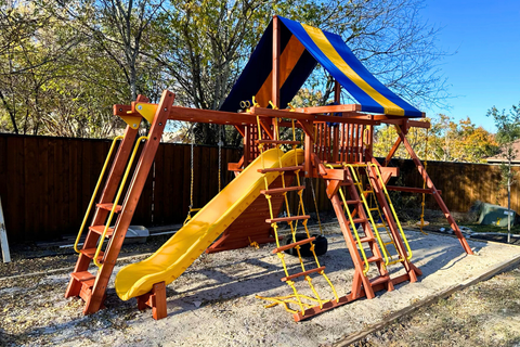 Colorful playground set with a slide and climbing structure in an outdoor setting.