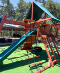 Colorful playground structure with slides and climbing areas on a sunny day.