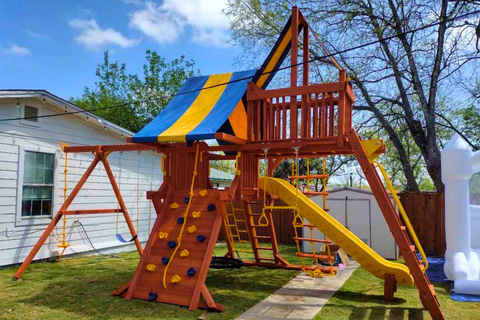 Colorful playground set with slides and climbing structures in a backyard.