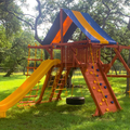 Colorful playground structure with slides and climbing elements in a park setting