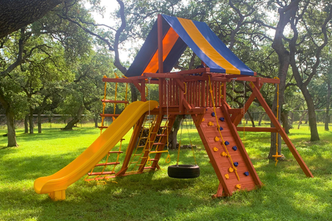 Colorful playground structure with slides and climbing elements in a park setting